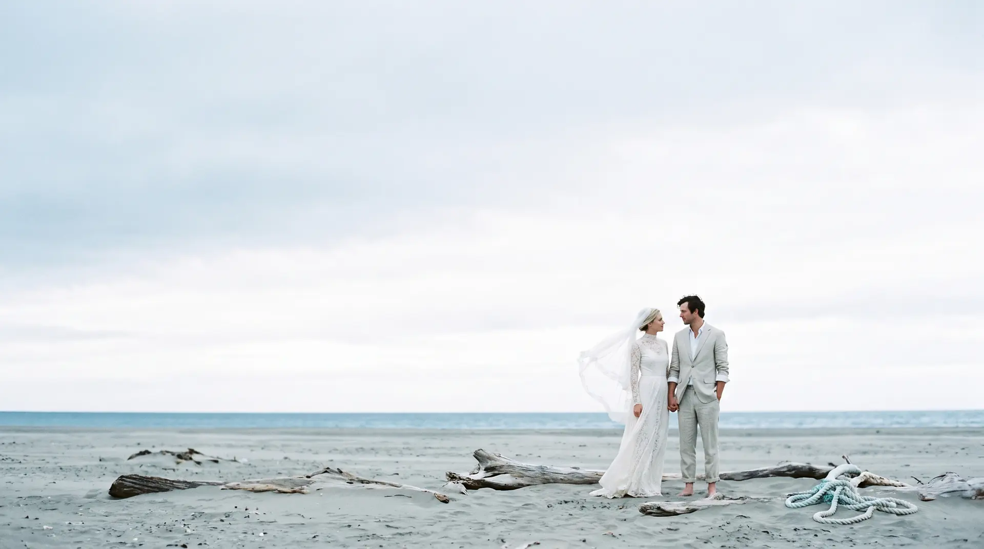 A couple on a wide grey shoreline